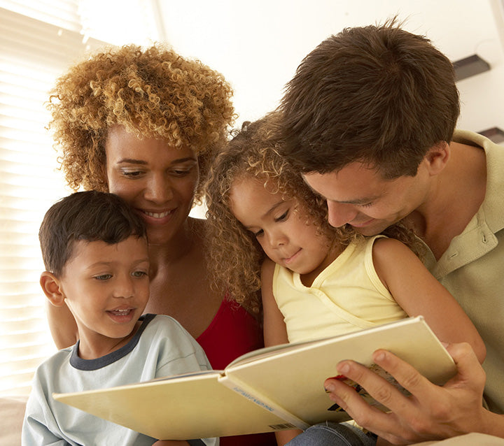 A mother and father reading to their two children